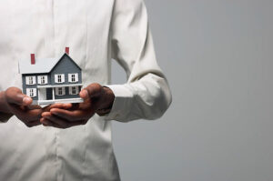 Man holding a house in his hands